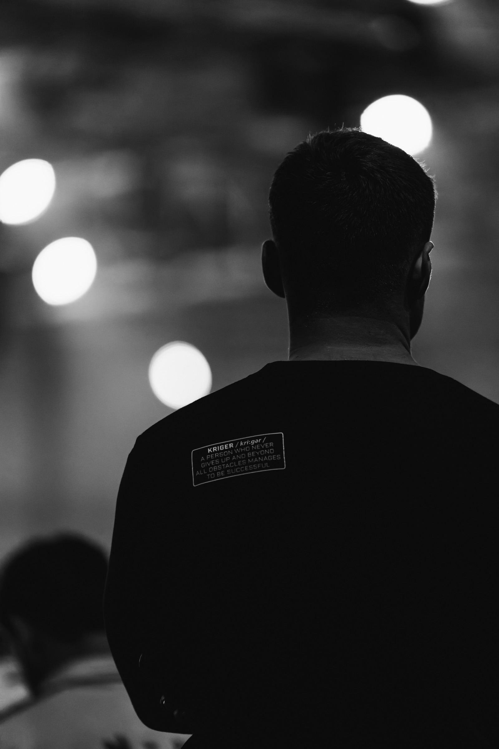 Kriger athlete from behind, shirt reading: a person who never gives up
